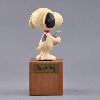 Rear three-quarter view of the wooden Snoopy figurine showing his black back marking and tail