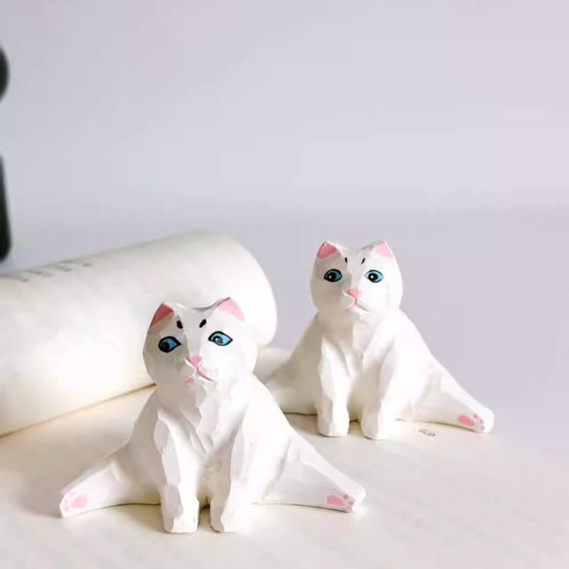Pair of split pose cat figurines on display