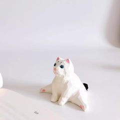 Split pose cat figurine sitting with legs stretched