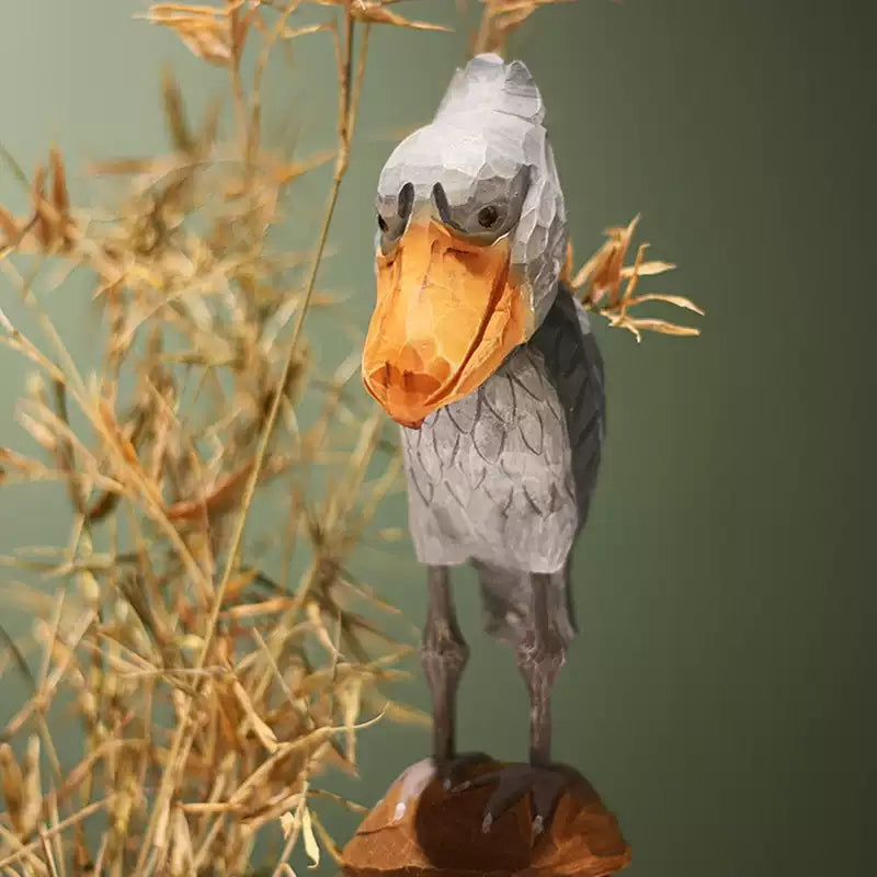 Standing wooden Shoebill with slender legs and spread feet on a brown base