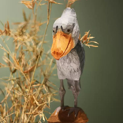Standing wooden Shoebill with slender legs and spread feet on a brown base