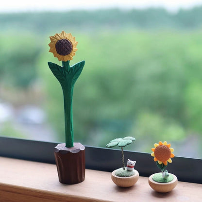 Sunflower pen in its wooden pot holder on a windowsill beside small clover and sunflower ornaments.