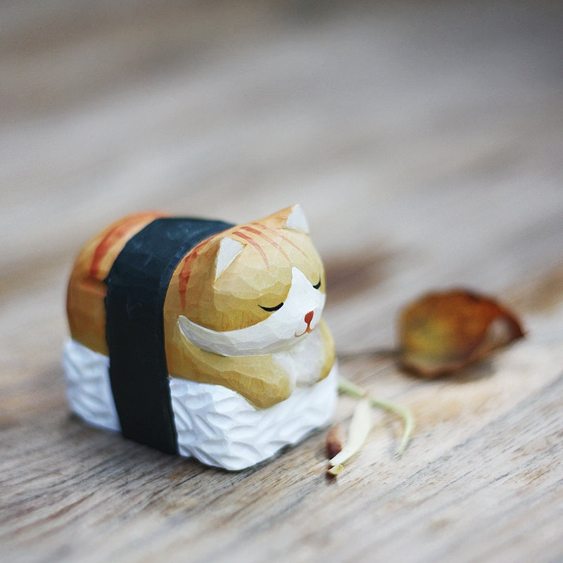 Sushi sleeping cat figurine placed on a table in the garden.