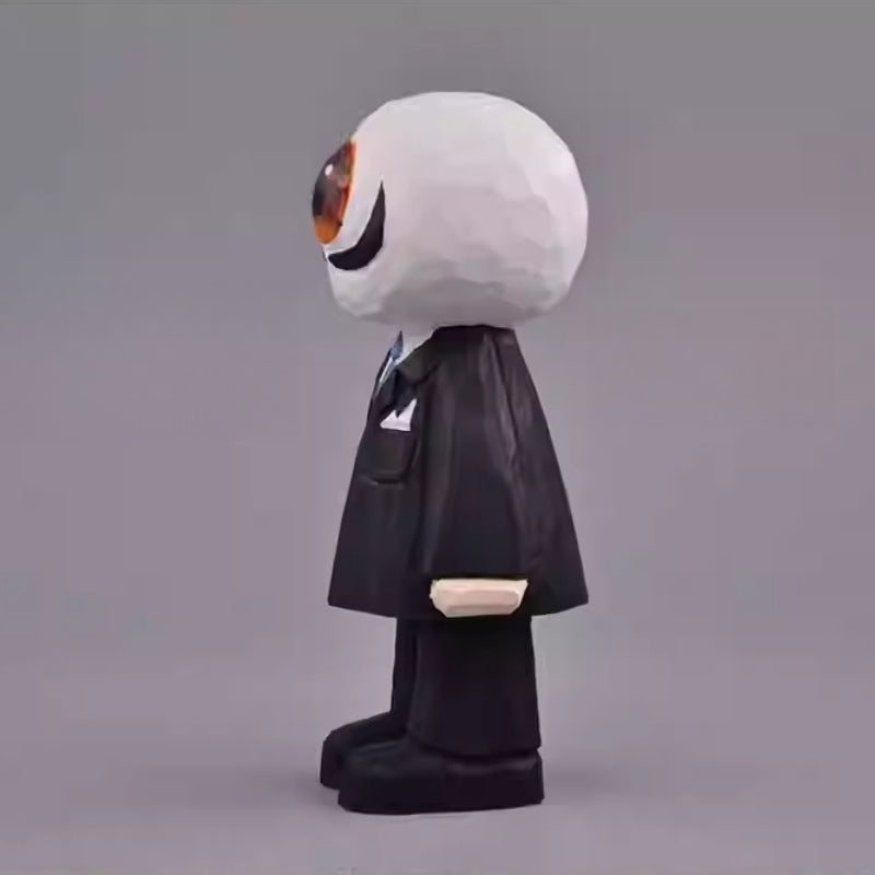 Side view of the wooden Eyeball Figure showing its black suit, pocket square, and the round, sculpted eyeball head.