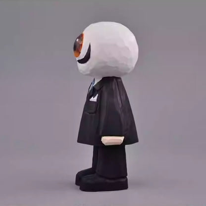 Side view of the wooden Eyeball Figure showing its black suit, pocket square, and the round, sculpted eyeball head.