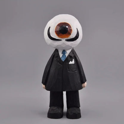 Wooden eyeball figure with a brown eye, curled black mustache, black suit, and blue tie, front view