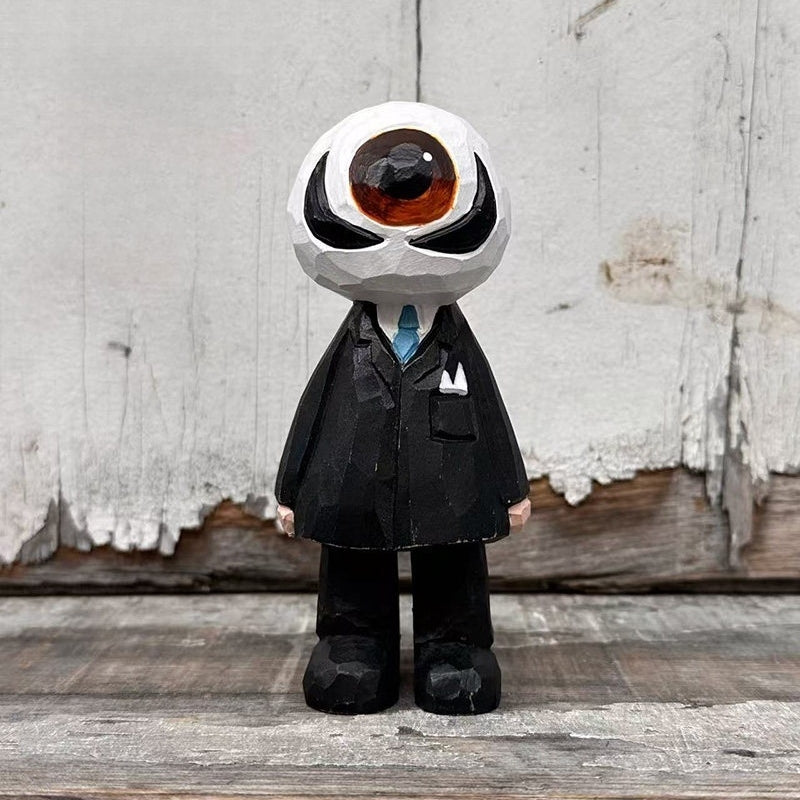 Wooden eyeball figure in a black suit and blue tie standing on wood against a white plank backdrop