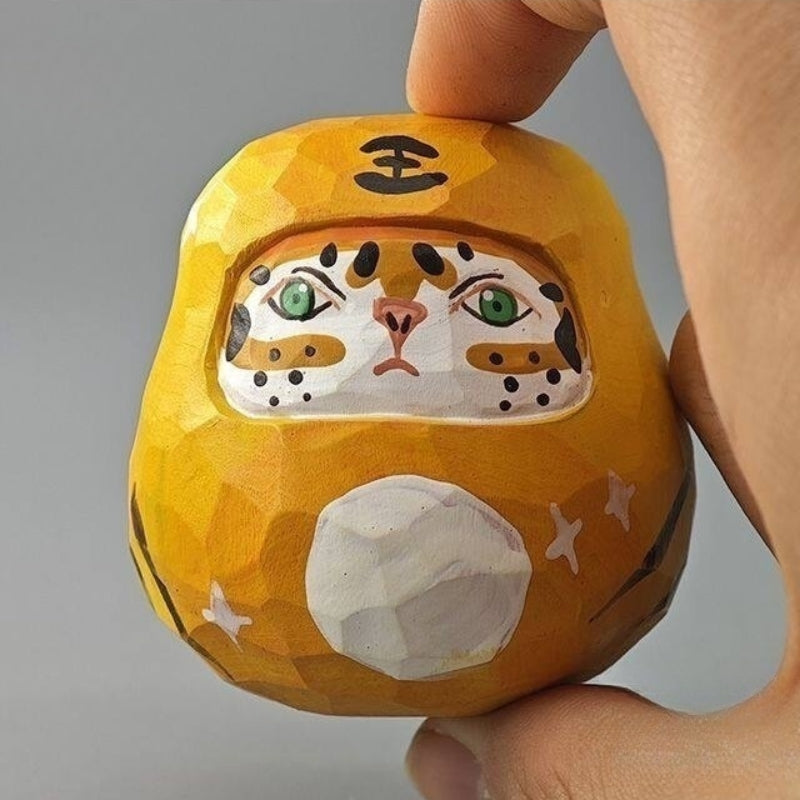Close detail of tiger daruma doll facial carving