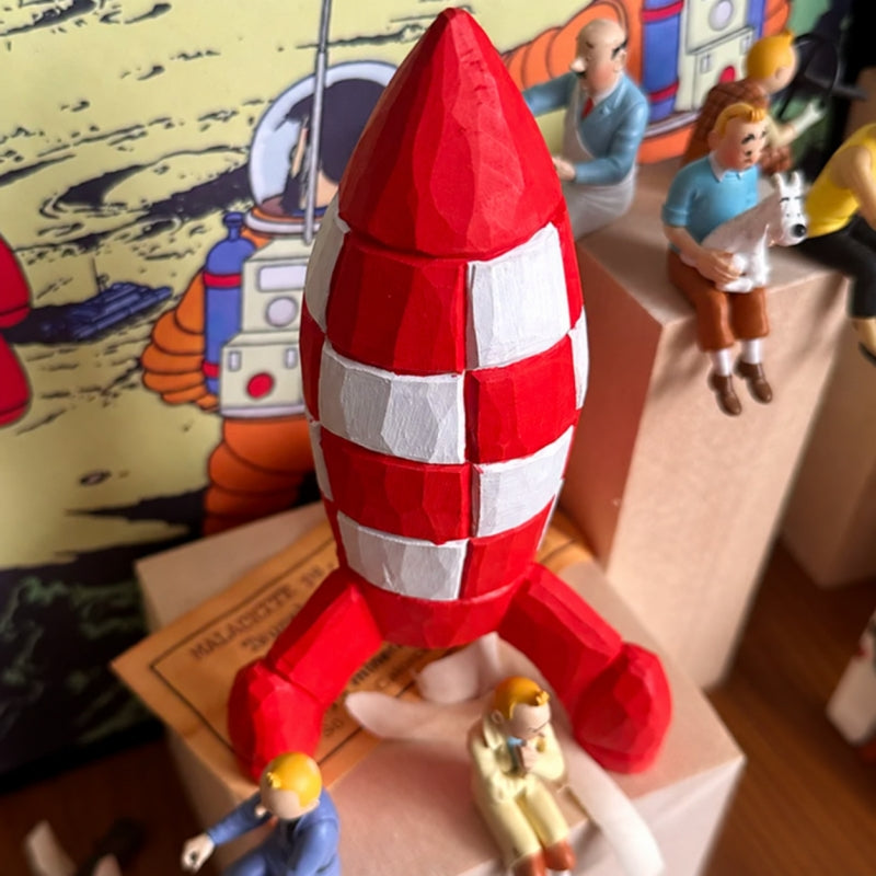 Overhead view of the wooden Tintin rocket with Tintin character figurines and a comic backdrop