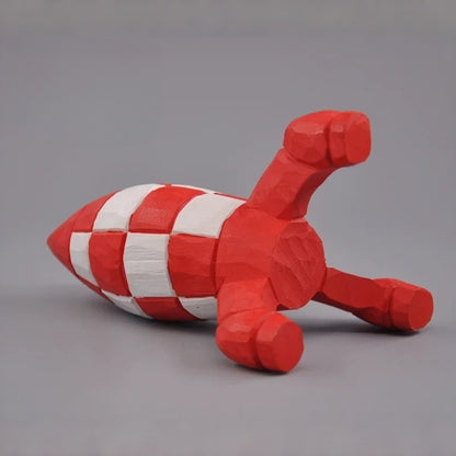 Wooden Tintin rocket lying on its side, showing the underside and three red fins