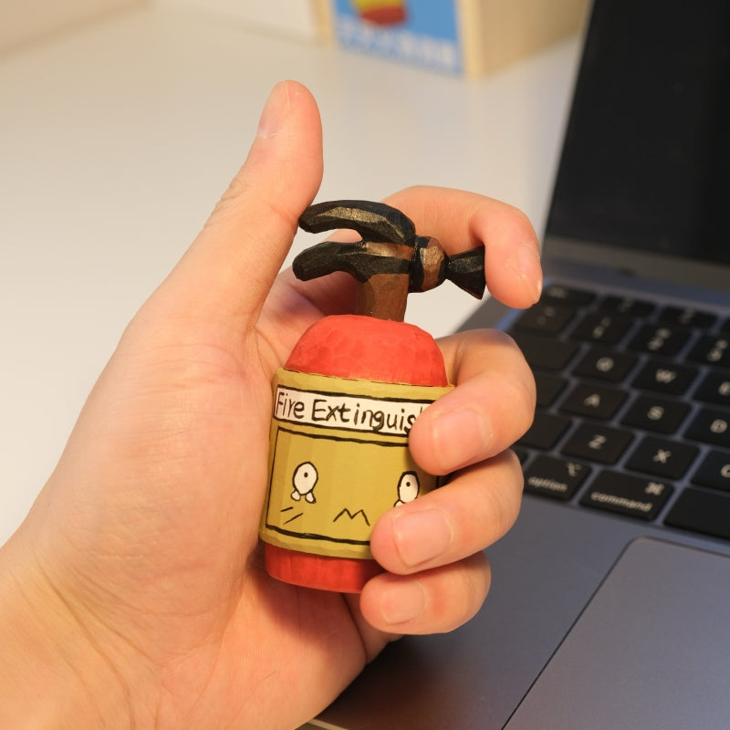 Wooden fire extinguisher figurine held in hand for size reference