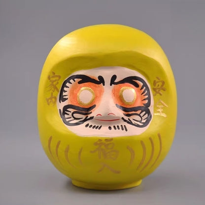 Yellow Japanese daruma doll wooden figurine