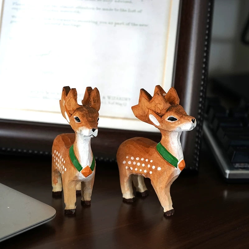 Two small Sika deer figurines with green scarves and hand-painted white spots