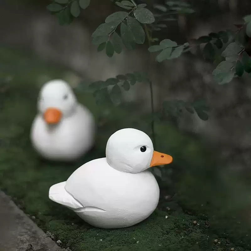 Two white wooden Call Ducks displayed together outdoors