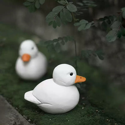 Two white wooden Call Ducks displayed together outdoors