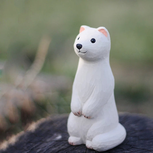 White weasel figurine standing upright on dark wooden stump