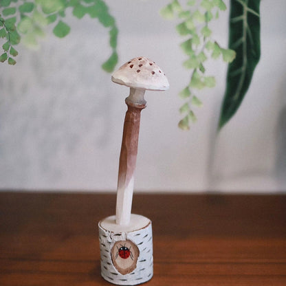 White-cap mushroom pen with brown spots standing in a white wooden holder painted with a ladybug.