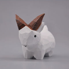 White wooden goat figurine in a front three-quarter view