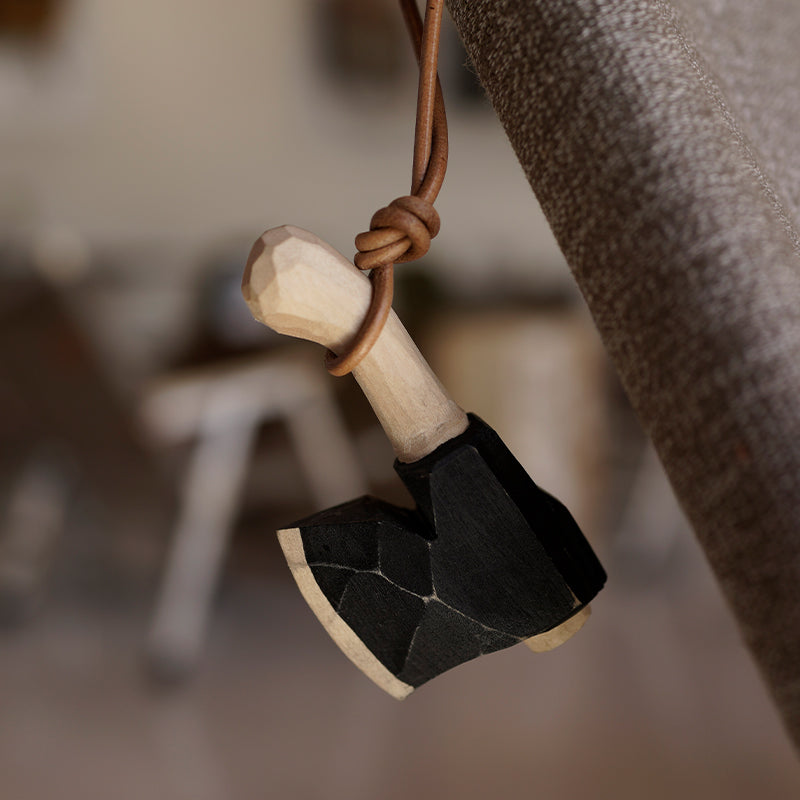 Wooden axe ornament hanging by a leather cord