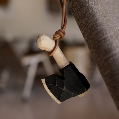 Wooden axe ornament hanging by a leather cord