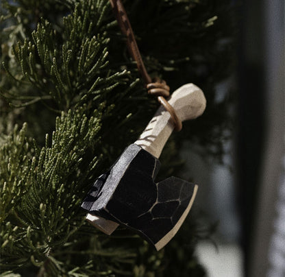 Wooden axe ornament hanging on a pine branch