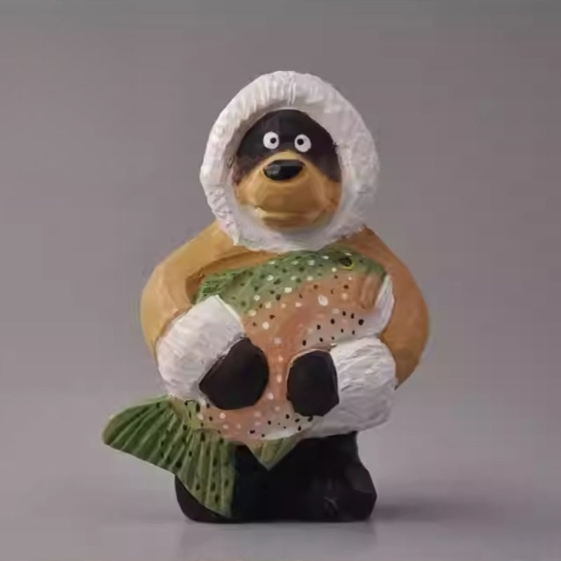 Wooden bear figurine holding a fish wearing winter coat