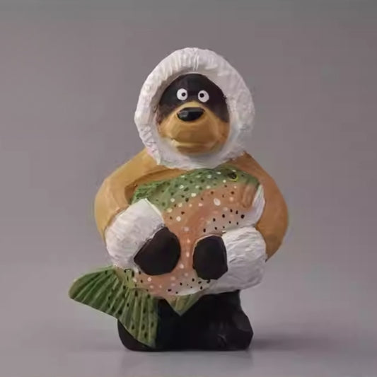Wooden bear figurine holding a fish wearing winter coat