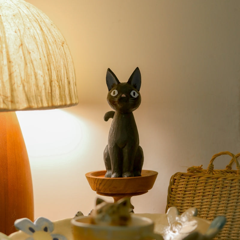 Wooden black cat figurine displayed beside table lamp
