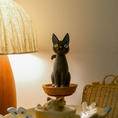 Wooden black cat figurine displayed beside table lamp