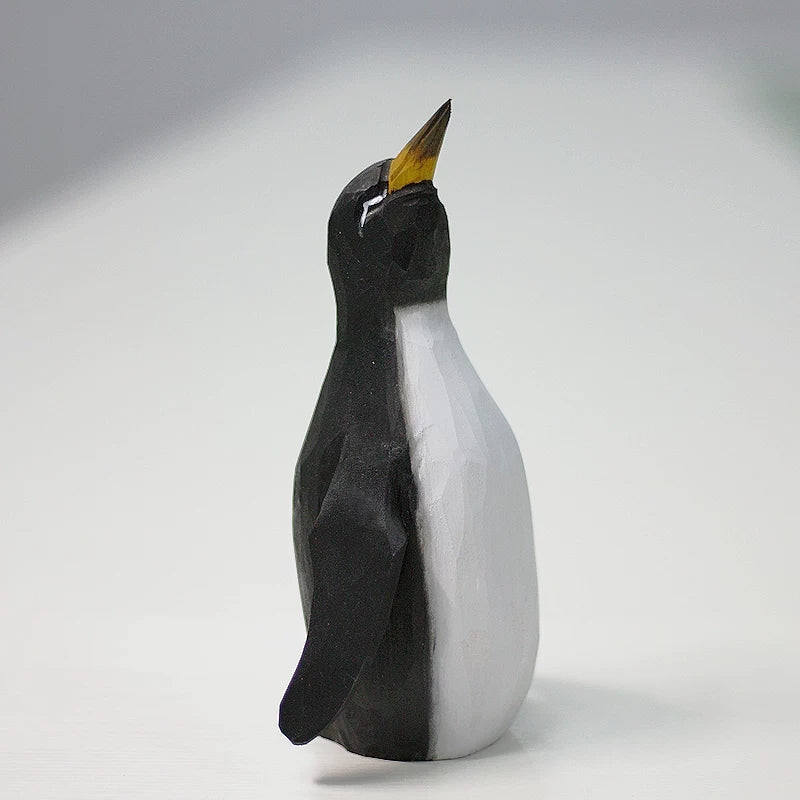 Black-and-white wooden father penguin with a raised beak and rounded white belly