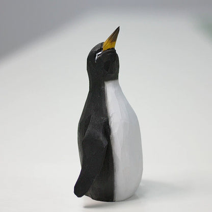 Black-and-white wooden father penguin with a raised beak and rounded white belly