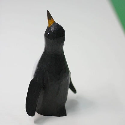 Rear three-quarter view of the black wooden father penguin with wings angled away from its body