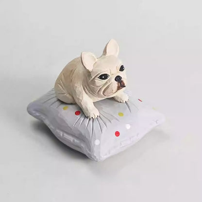 Wooden French bulldog figurine viewed from the front on its cushion