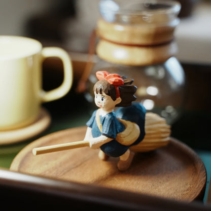Wooden Kiki figurine displayed on coffee table tray