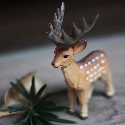 Male wooden deer figurine with broad dark antlers, brown shading, and white spots