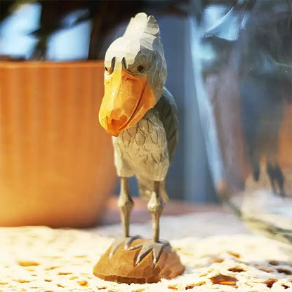 Full front view of a wooden Shoebill standing upright on its carved base