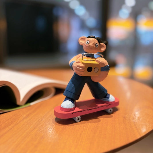 Wooden skater girl figurine with boombox riding a skateboard, full front view