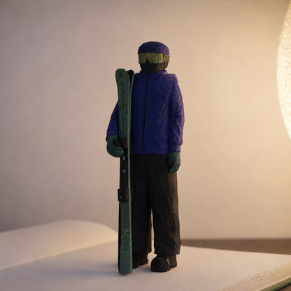 Hand-carved wooden skier holding green skis beside a purple jacket