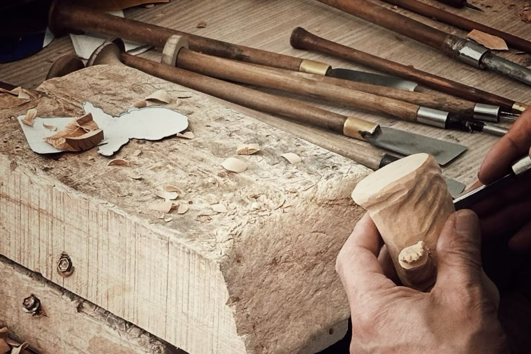 Wooden Smile artisan carving a wooden figurine by hand
