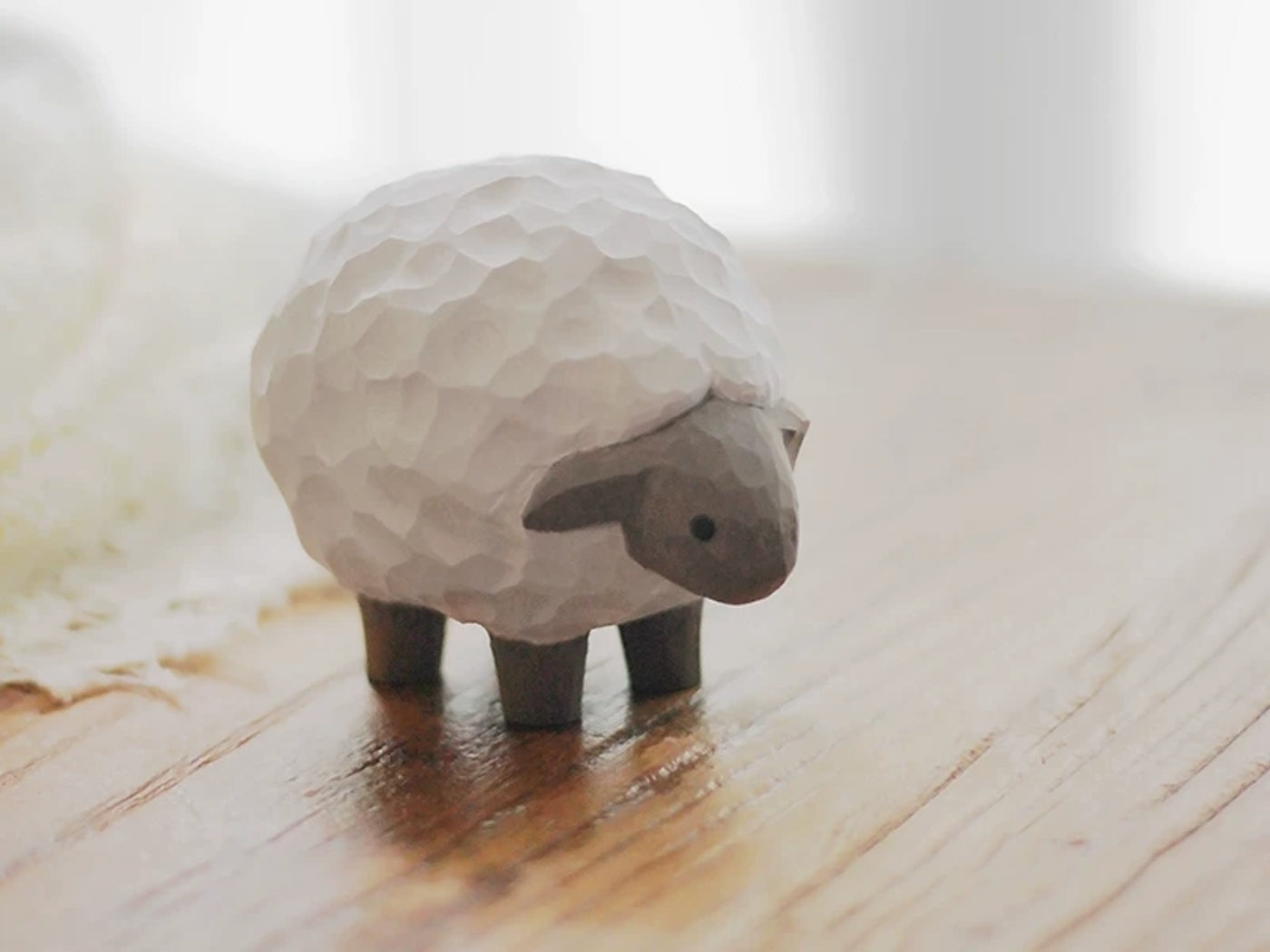 Hand-carved lamb figurine displayed in an everyday space