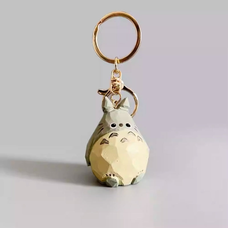 Hand-carved wooden Totoro keychain figurine standing upright with gold key ring.