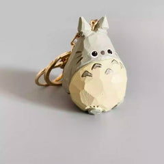 Angled front view of the hand-painted wooden Totoro keychain showing carved details.