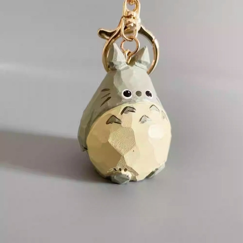 Side angle of the wooden Totoro keychain highlighting the hand-carved and painted finish.