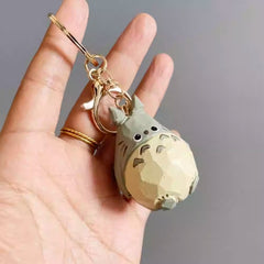 Wooden Totoro keychain displayed on hand, showing compact size and detailed craftsmanship.