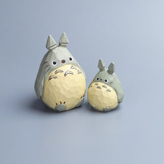 Two wooden Totoro carvings, large and small, shown from the front with detailed painting.