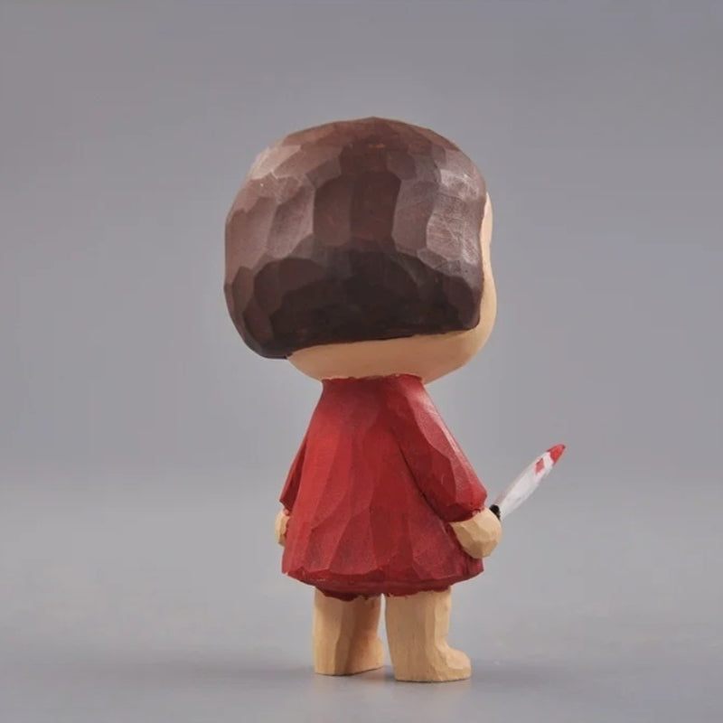 Rear view of the wooden girl figurine showing her brown bob and red dress