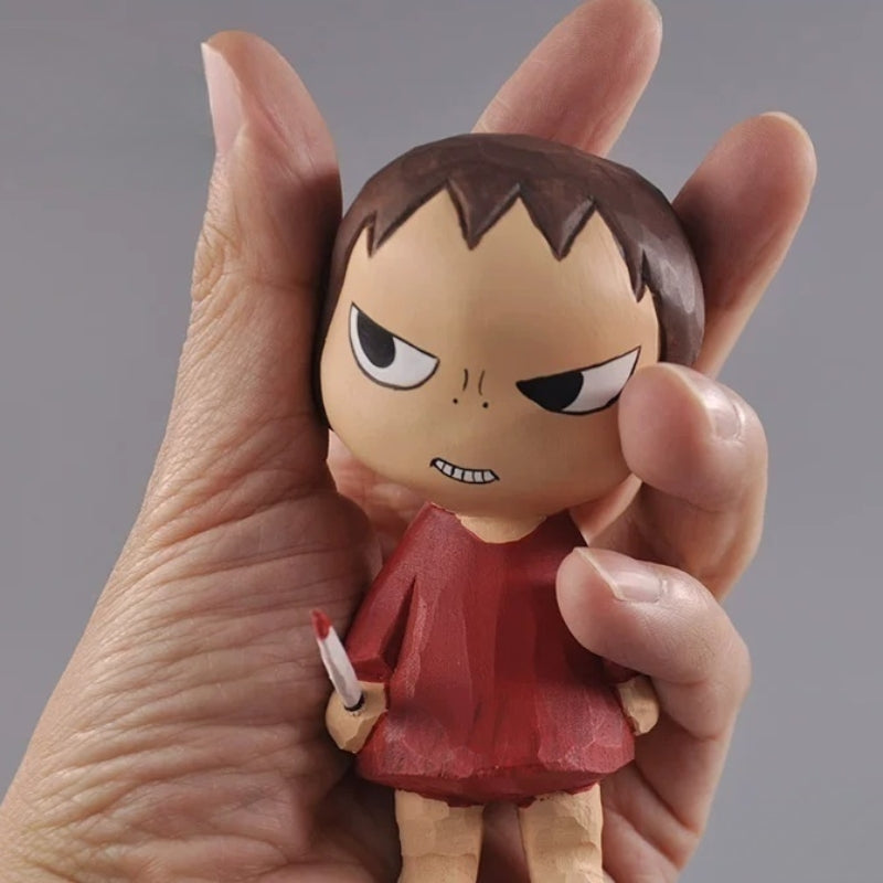 Wooden girl figurine with a miniature knife held in a person's palm