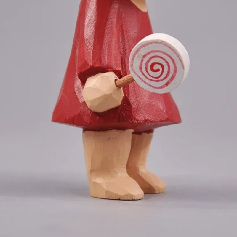 Close view of the spiral lollipop fitted into the wooden girl's hand