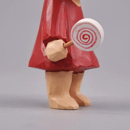 Close view of the spiral lollipop fitted into the wooden girl's hand