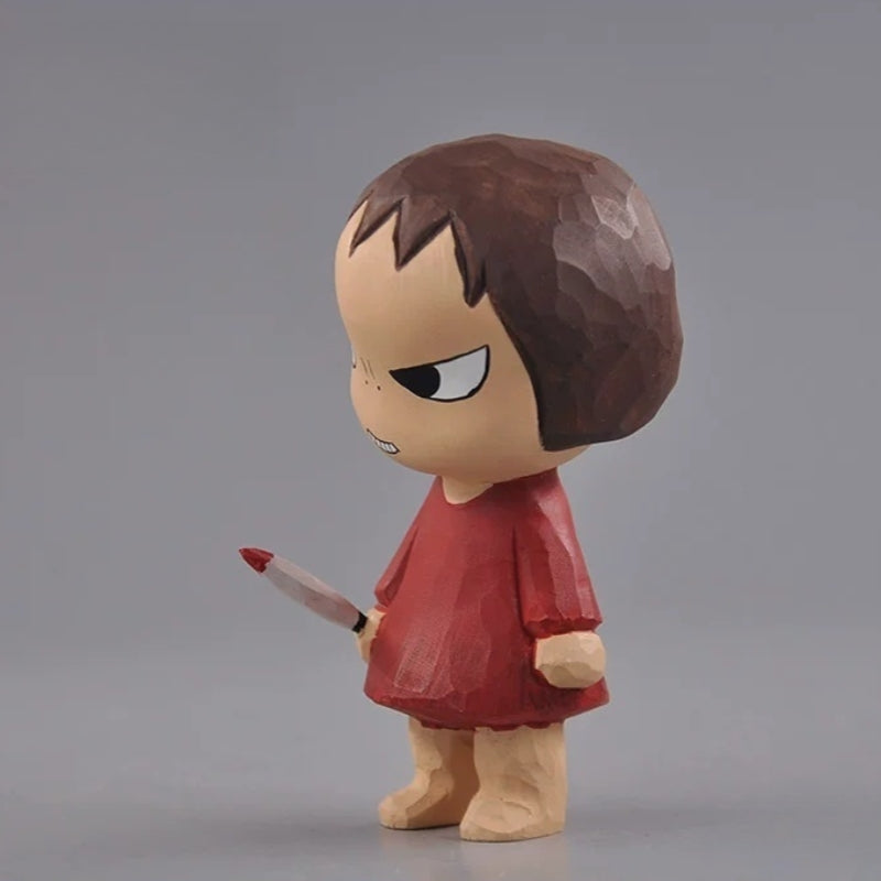 Side view of the wooden girl figurine holding a miniature knife